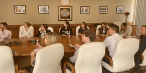 GLO srudents sitting around the table listening to a business speaker